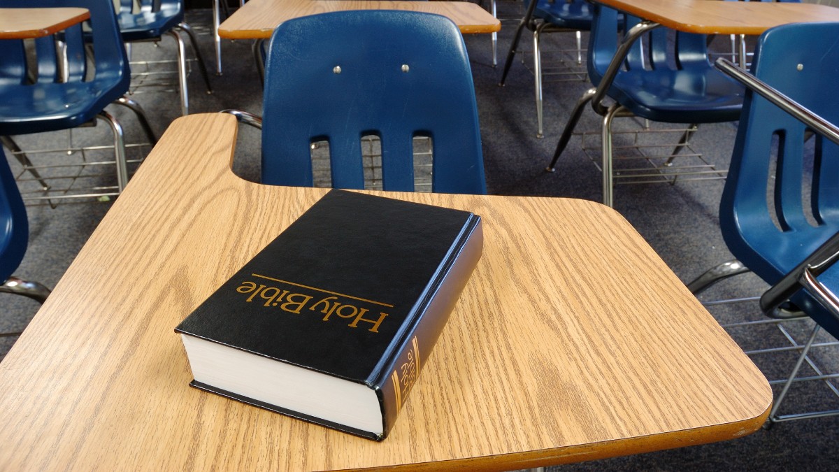 A Bible sitting on a desk in a school classroom