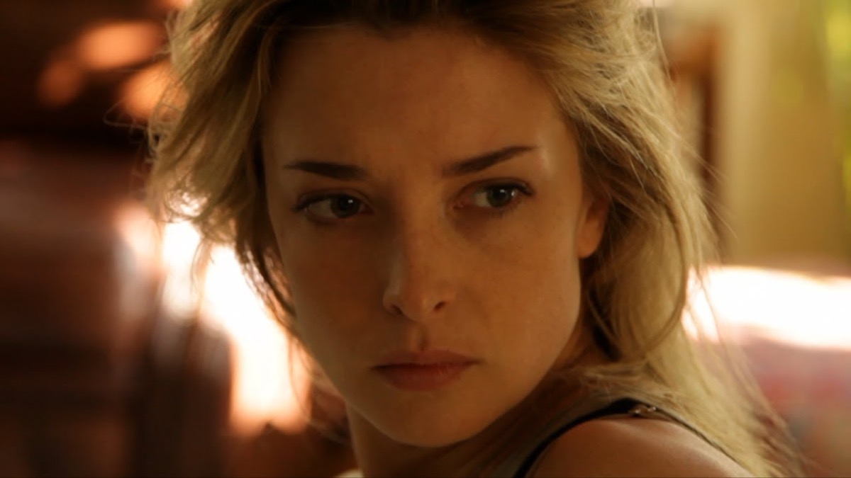 A blonde woman looks suspiciously over her shoulder in "Coherence" 