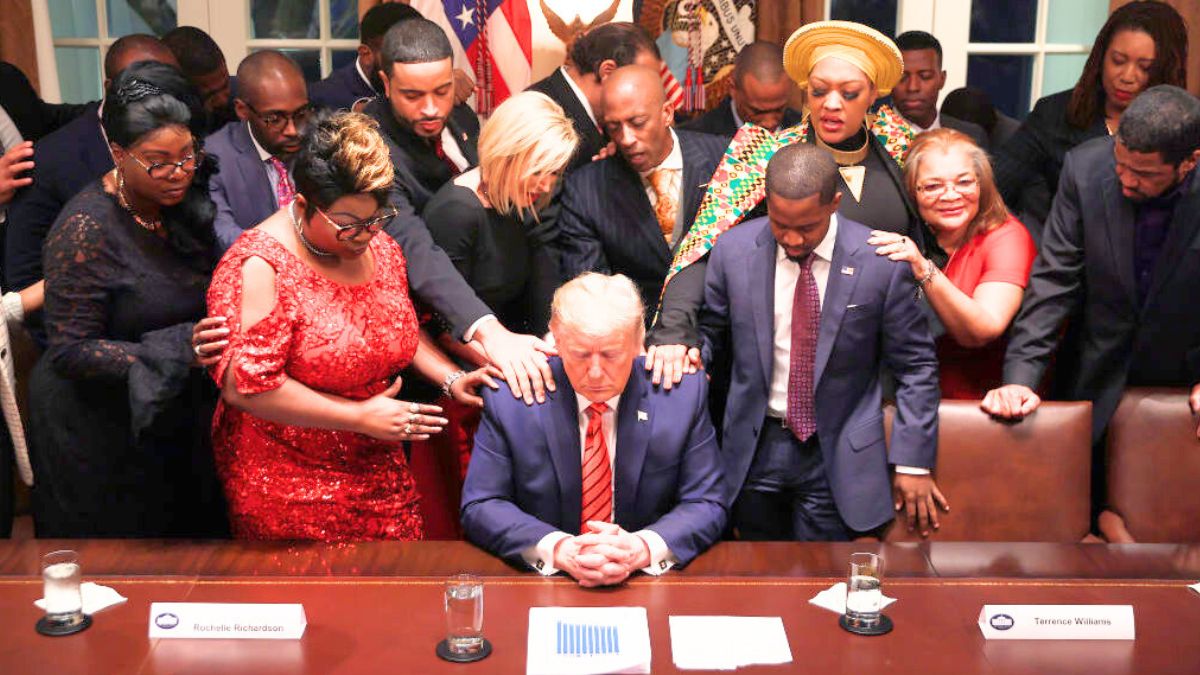 WASHINGTON, DC - FEBRUARY 27: African American supporters lay their hands on U.S. President Donald Trump as they pray for him at the conclusion of a news conference and meeting in the Cabinet Room at the White House February 27, 2020 in Washington, DC. The president talked about the economic advances African Americans have made under his administration, about the government's response to the global coronavirus threat and how dishonest he thinks the news media can be to him. He did not answer reporters' questions about the S&P 500 taking its worst loss in almost nine years. (Photo by Chip Somodevilla/Getty Images)