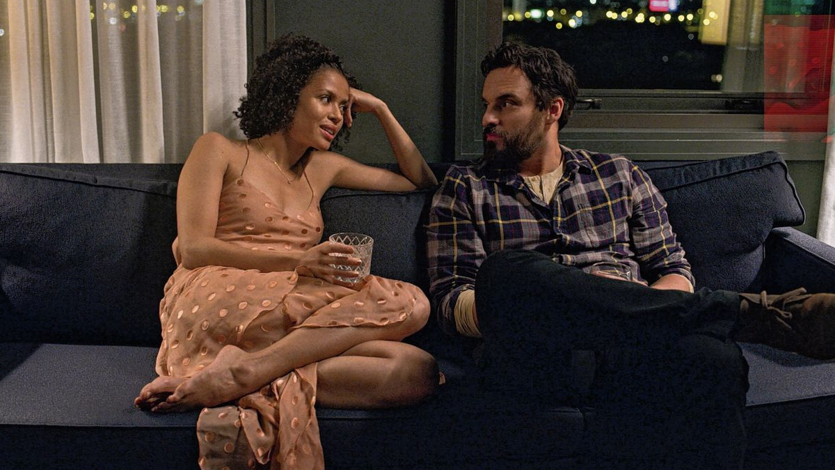 Gugu Mbatha-Raw and Jake Johnson sitting on a couch in 'Easy' on Netflix 