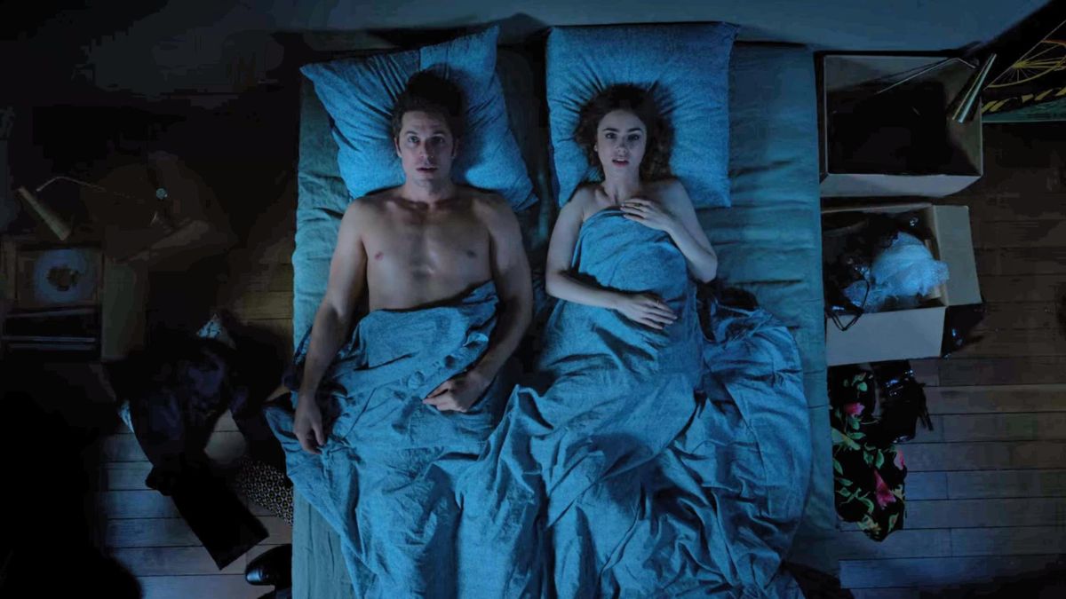 Lucas Bravo as Gabriel and Lily Collins as Emily Cooper lie in bed in Emily In Paris season 1