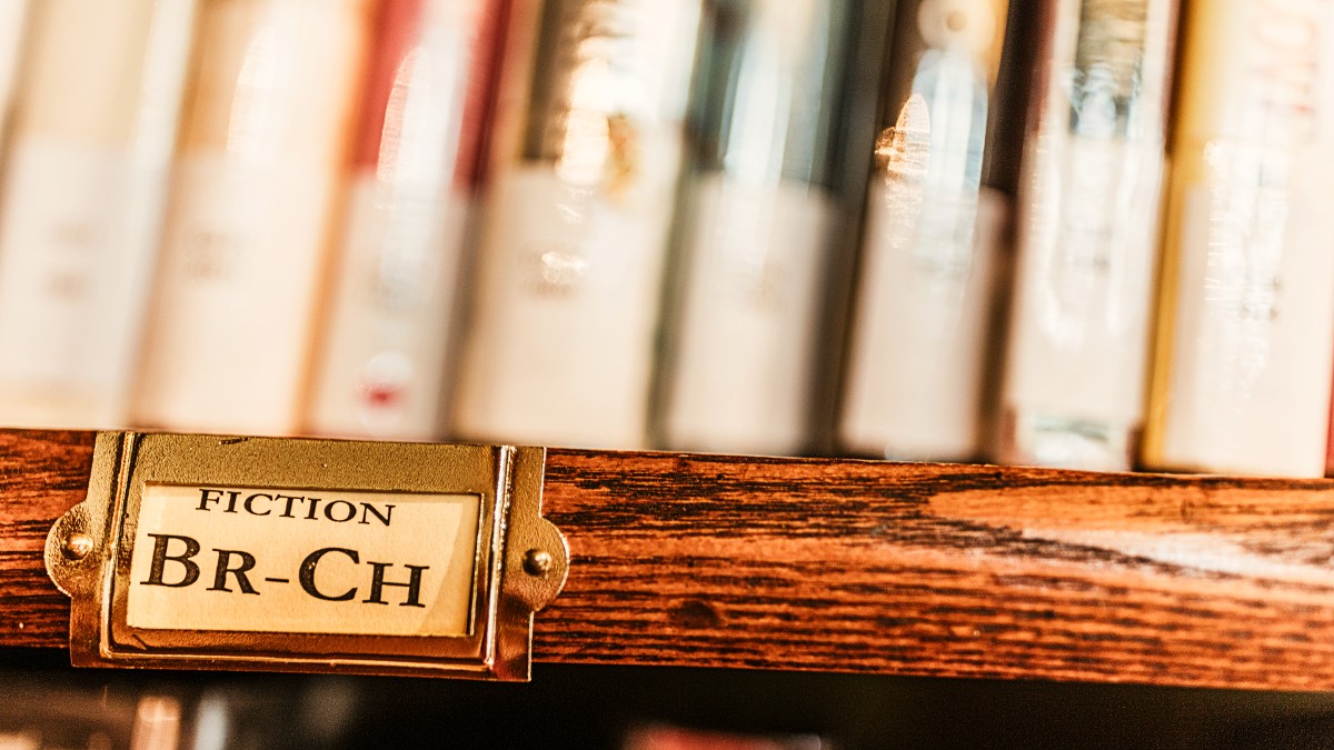 A bookshelf with books labeled "fiction"