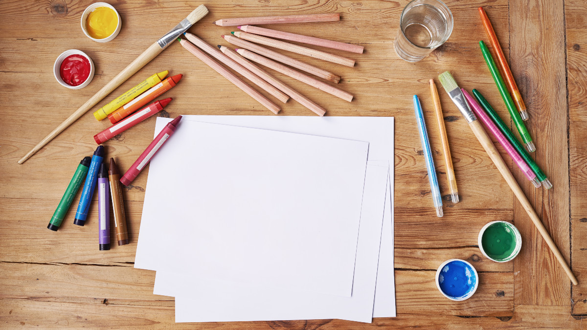 Creativity takes courage - stock photo Blank paper with painting supplies and pencils on a wooden table