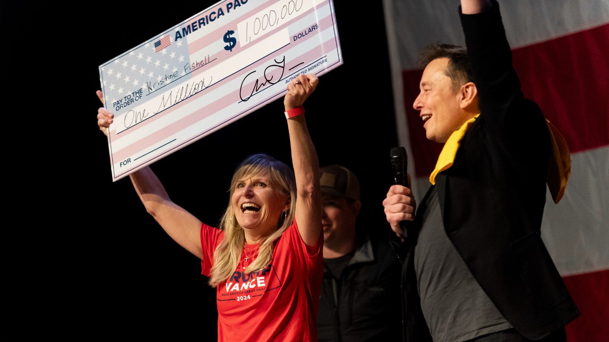 Elon Musk presents a $1 million check to Kristine Fishell at the Roxain Theater