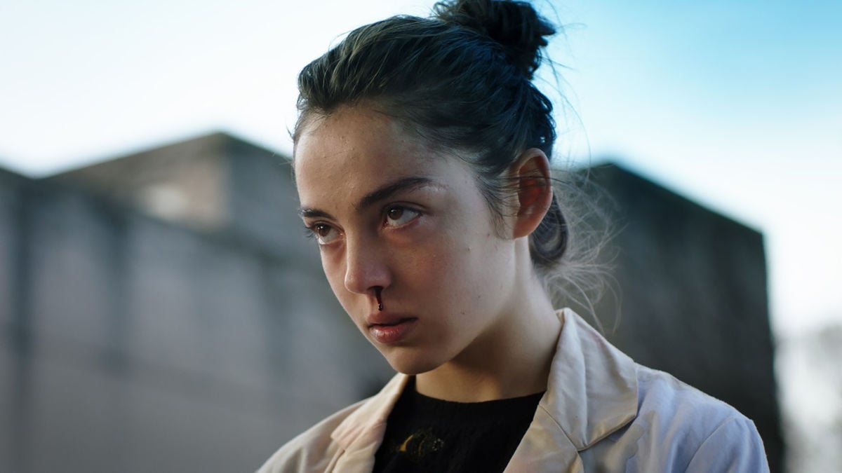 A young woman stares ominously with a bloody nose in "Raw"