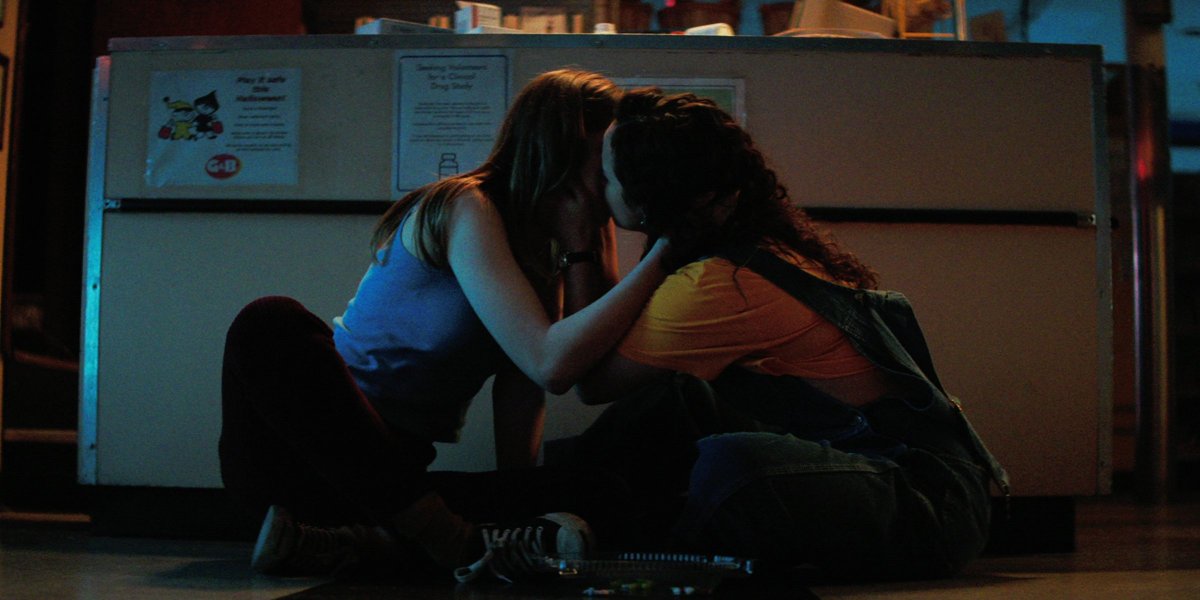 Two young women kiss on the floor in "Fear Street" 