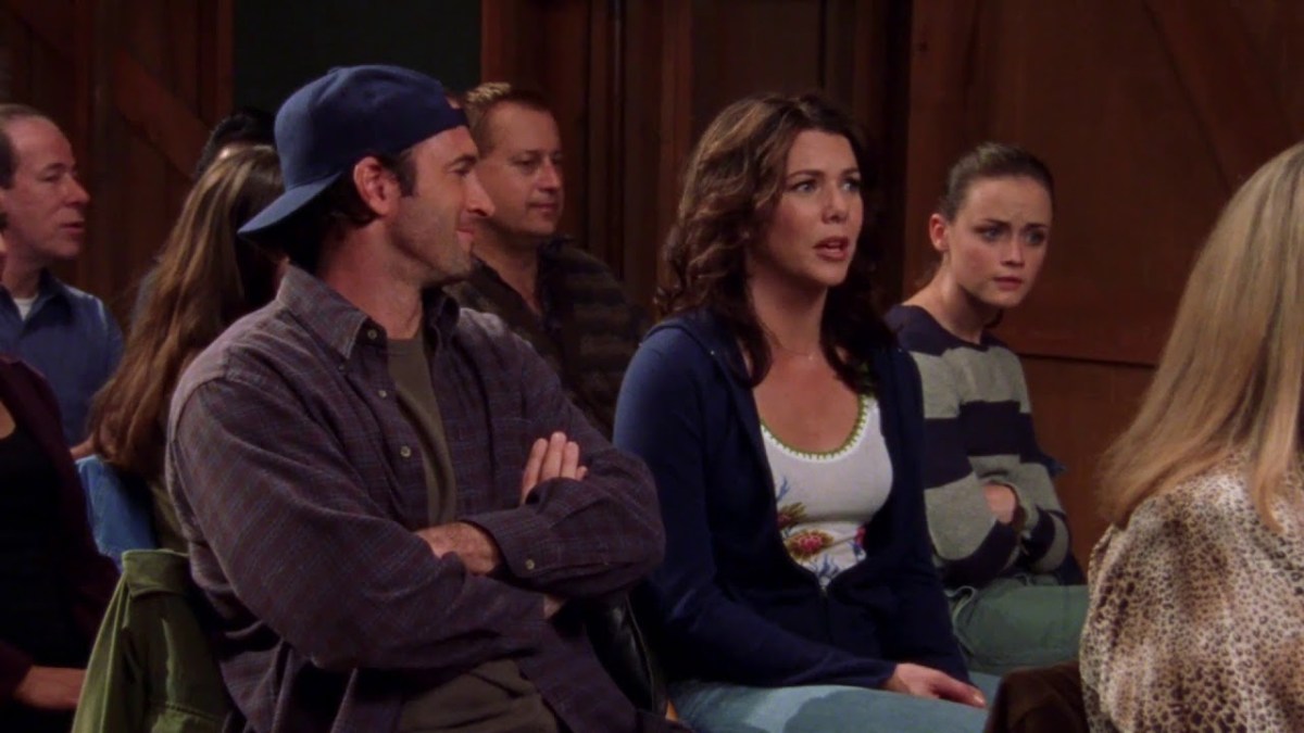 Luke, Lorelai and Rory at a town meeting in Gilmore Girls 