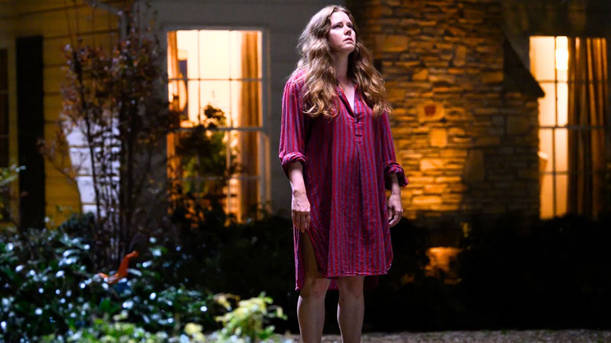 Amy Adams stands outside as "Mother" in 'Nightbitch'