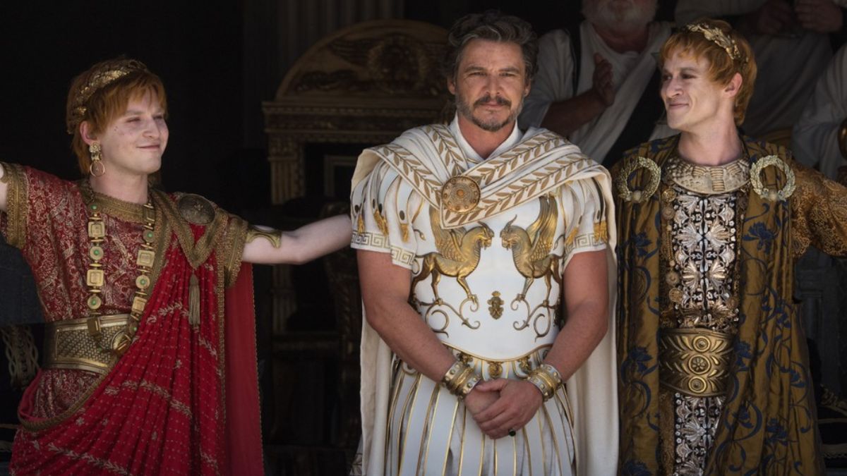 Fred Hechinger as Emperor Caracalla and Joseph Quinn as Emperor Geta smile and flank Pedro Pascal as General Acacius of Rome in Gladiator II