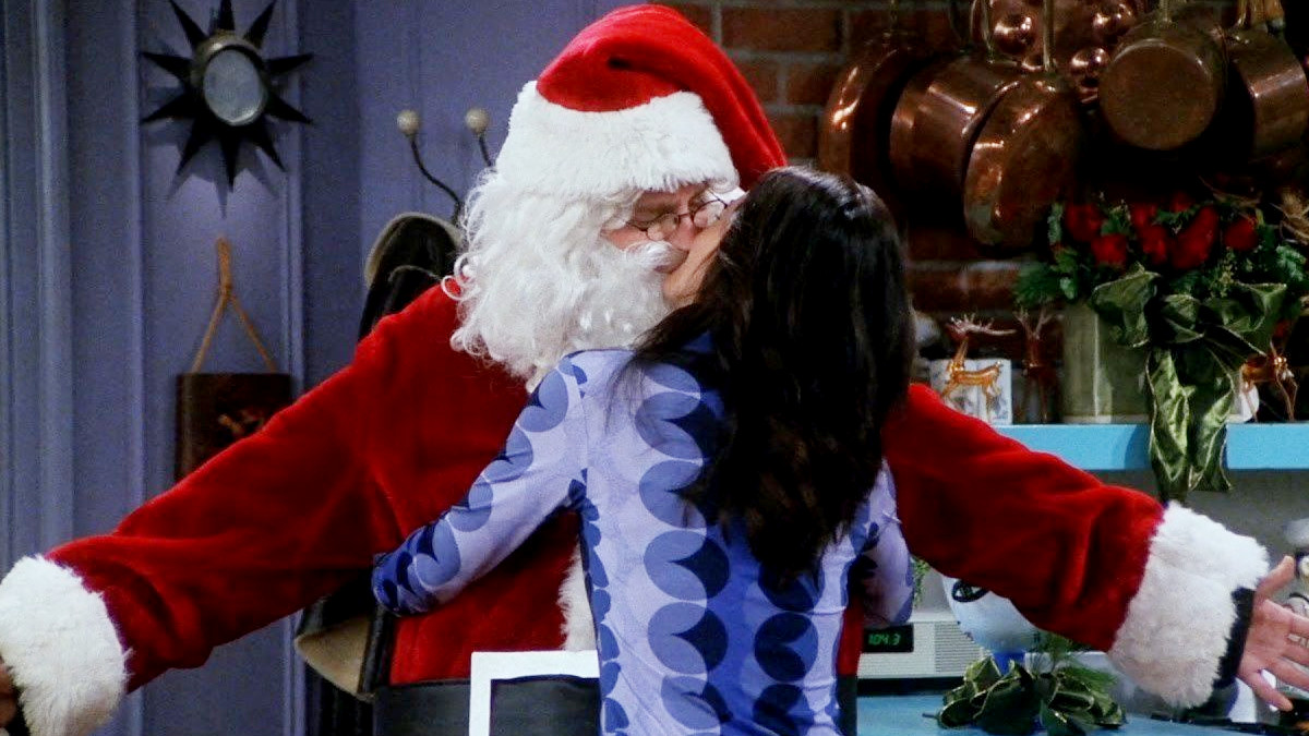 Chandler and Monica embrace while Chandler is dressed as Santa in the 'Friends' season 7 holiday episode