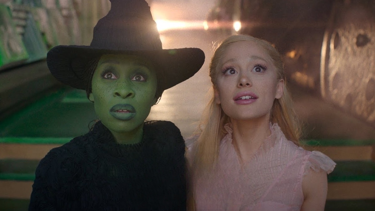 L-R: Cynthia Erivo as Elphaba and Ariana Grande as Glinda for the upcoming Wicked movie. Both are staring at the distance, in awe.