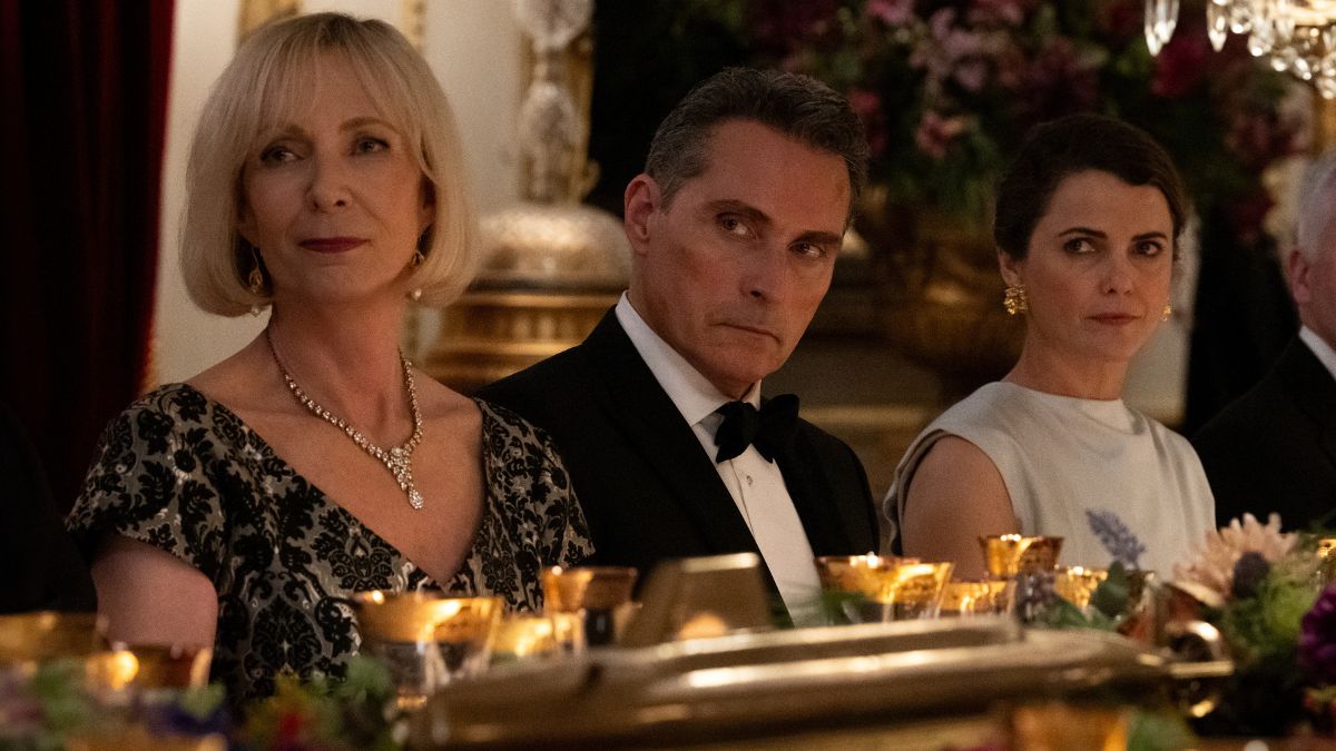 Allison Janney as Grace Penn, Rufus Sewell as Hal Wyler, and Keri Russell as Kate Wyler sit at a dinner table in a scene from The Diplomat season 2