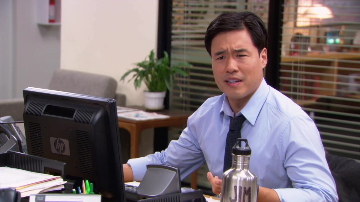 randall park at a desk looking confused