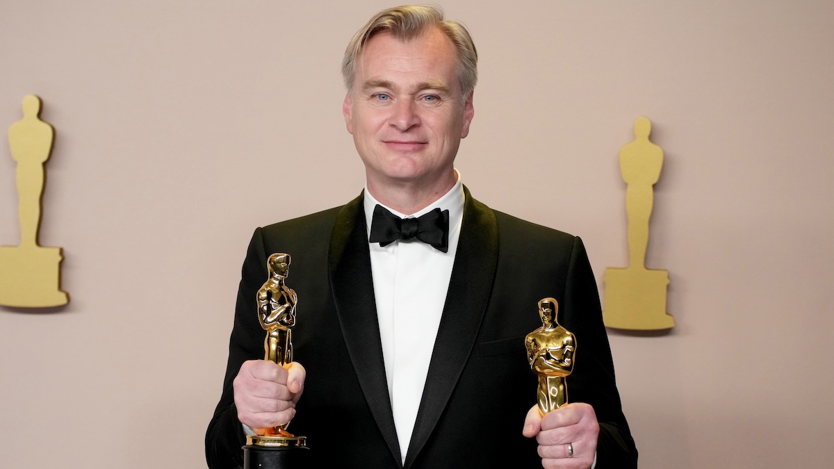 Christopher Nolan holding 2 oscars