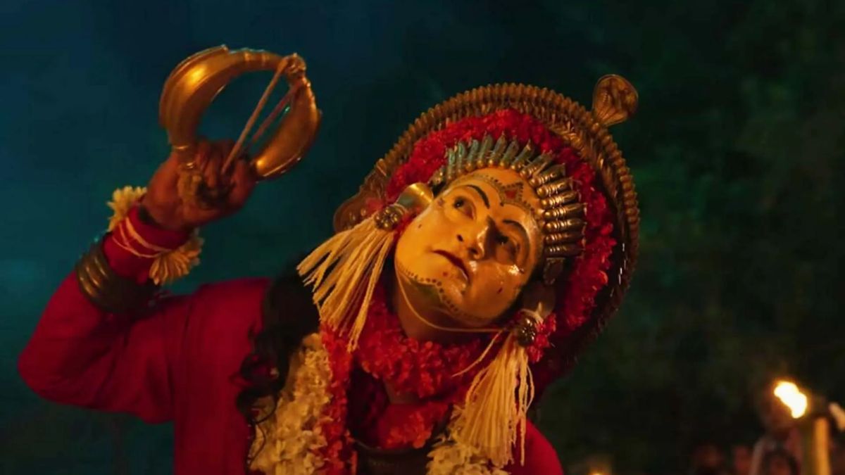 A Bhoota Kola dance performer with a painted face and headgear from South India