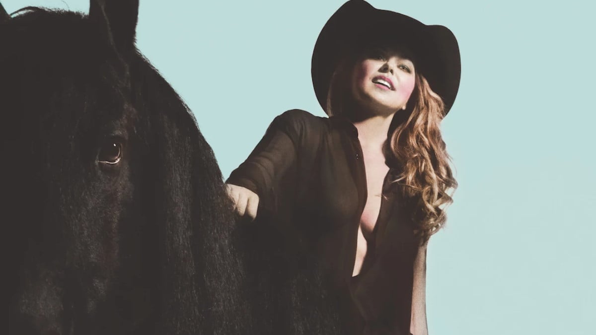 Shania Twain's album cover for 'Queen of Me' with the singer sitting on a black horse