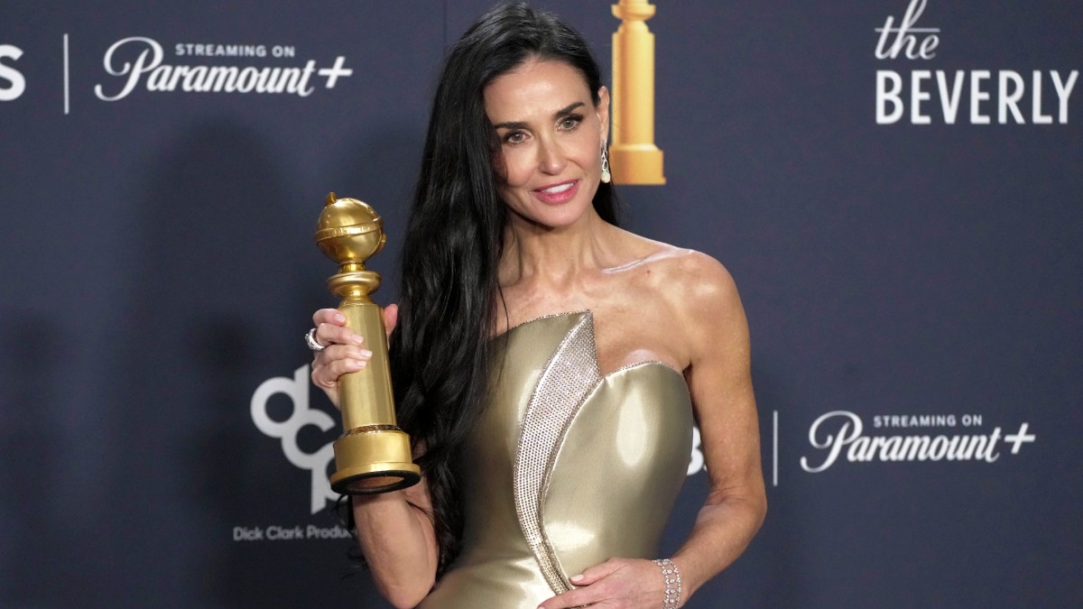 Demi Moore posing with her Golden Globe statue at the 82nd Golden Globes