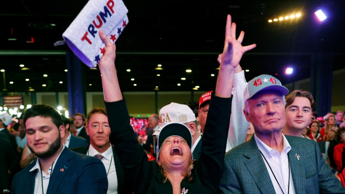 A Trump supporter shouts with her hands in the air at a Pam Beach election watch party