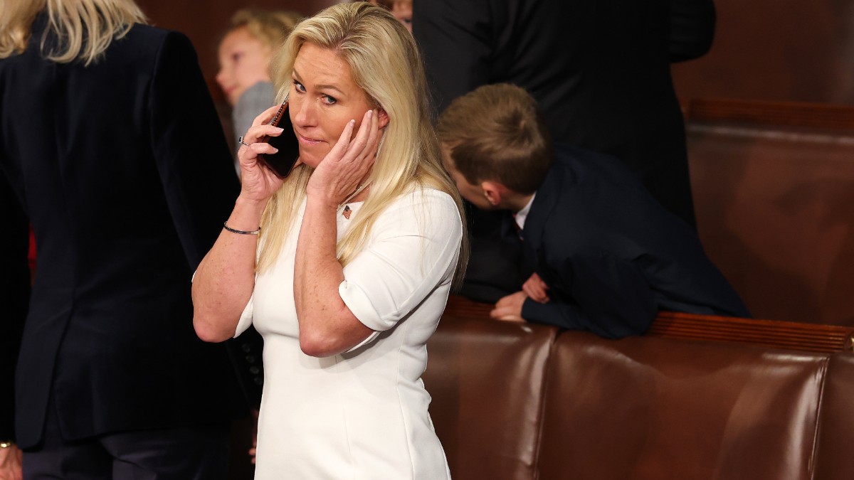 Marjorie Taylor Greene talks on the phone as the House prepares to vote on the Speaker of the House