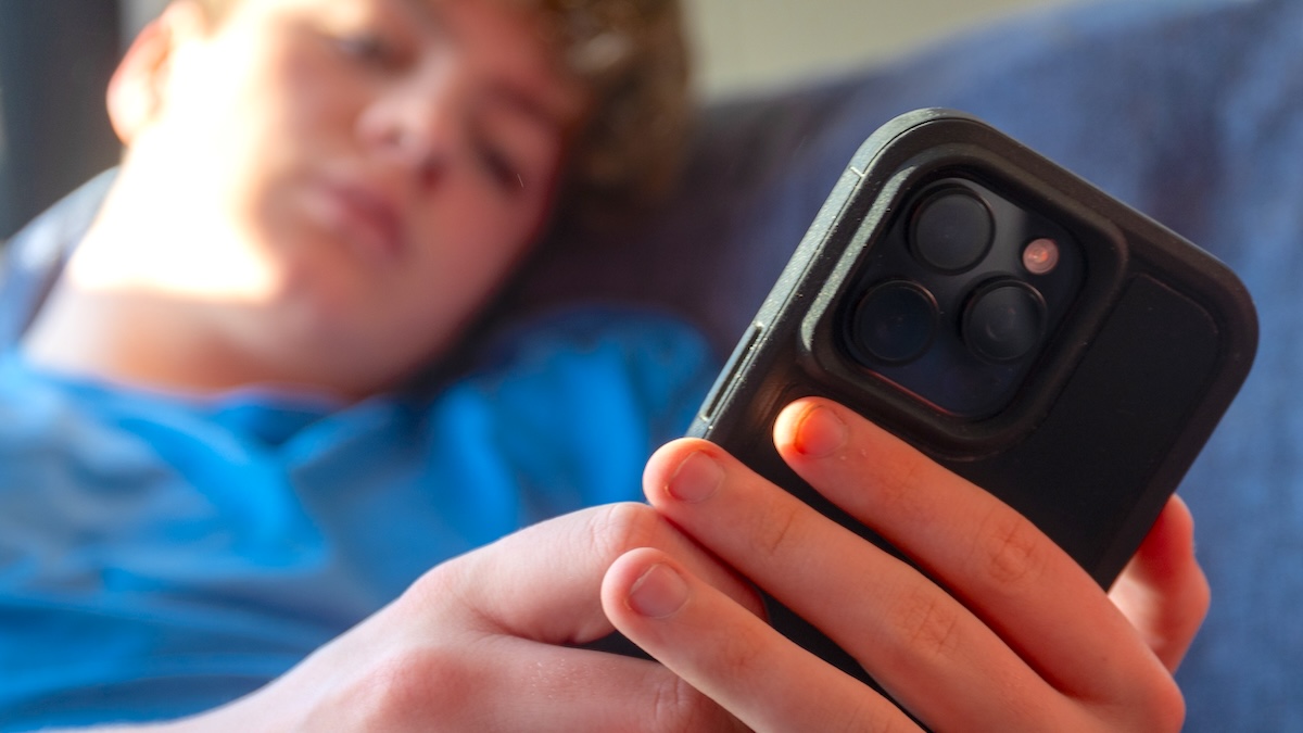 A 14-year-old boy looks at a iPhone screen