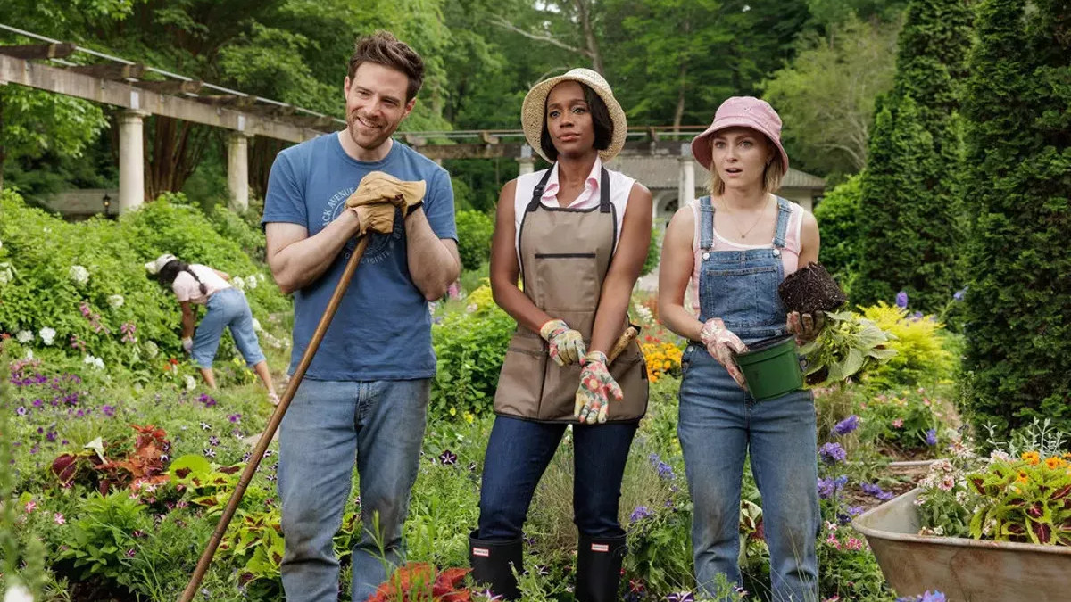 Ben Rappaport, Aja Naomi King and AnnaSophie Robb stand in a garden in 'Grosse Pointe Garden Society'