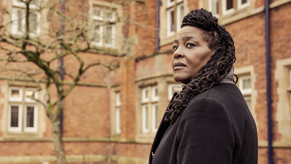 A woman in front of a brick building looks over her shoulder in "Inspector Ellis"