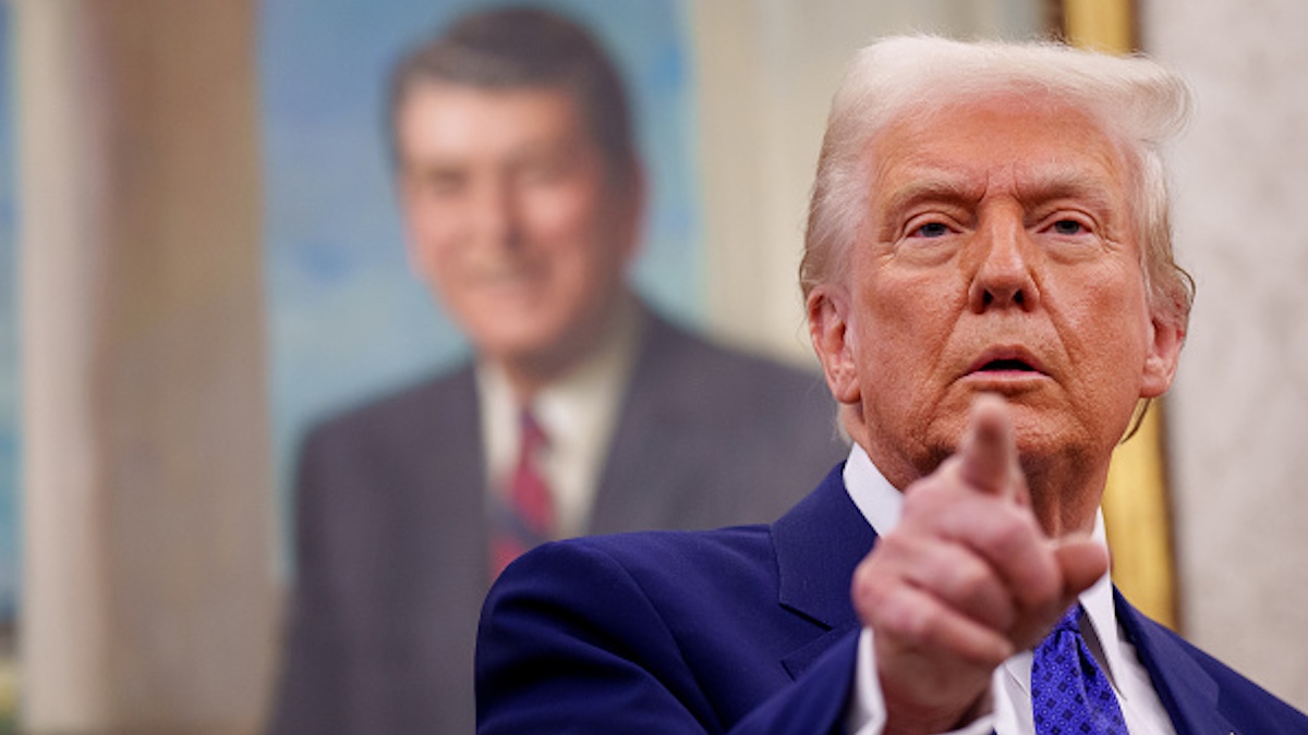 Trump pointing at a reporter in the Oval Office in front of a portrait of Ronald Reagan.